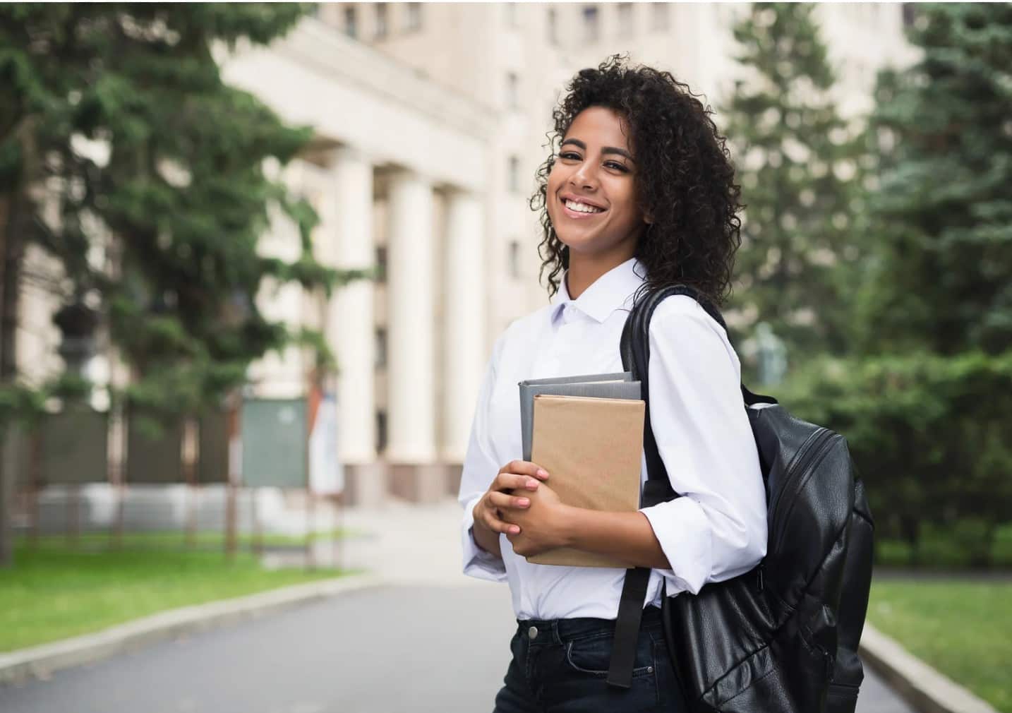 College student smiling with books